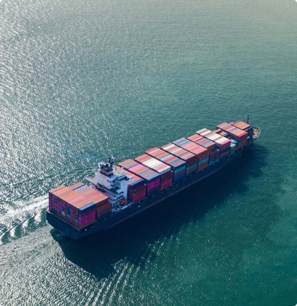A large container ship sailing across a calm, open sea.