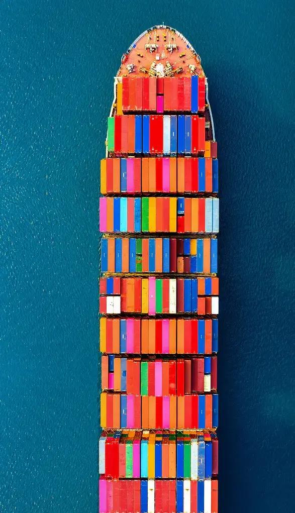 Aerial view of the front section of a Trasegro cargo ship loaded with colorful shipping containers at sea.