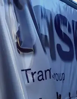 Partially folded trailer curtain displaying the Trasegro Transport Group logo.