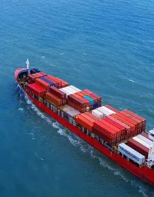 Cargo ship labeled "TRASEGRO" transporting shipping containers across the ocean.